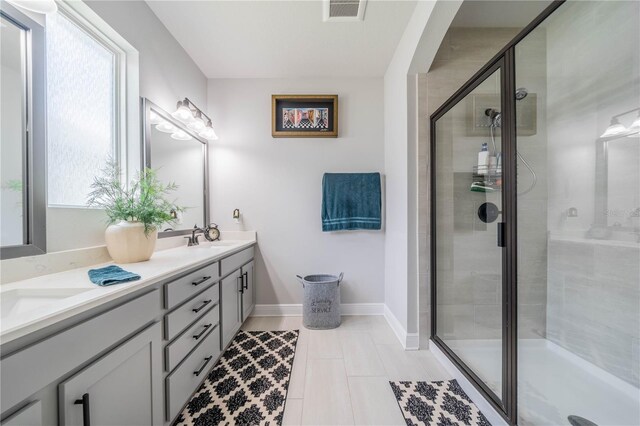 5538 Spanish Moss Cv, Bradenton, FL 34203 - bathroom with a stall shower, double vanity, tile patterned flooring, and baseboards