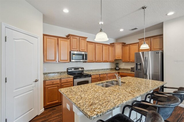 12831 White Bluff Rd, Hudson, FL 34669 - kitchen featuring appliances with stainless steel finishes, a sink, a breakfast bar area, dark wood-style flooring, and an island with sink