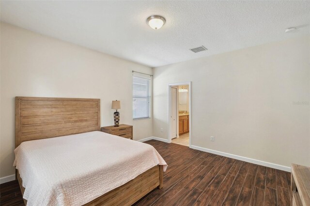 12831 White Bluff Rd, Hudson, FL 34669 - bedroom featuring dark wood finished floors, baseboards, and ensuite bath
