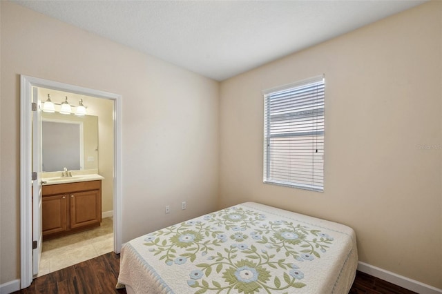 12831 White Bluff Rd, Hudson, FL 34669 - bedroom featuring a sink, dark wood finished floors, baseboards, and connected bathroom
