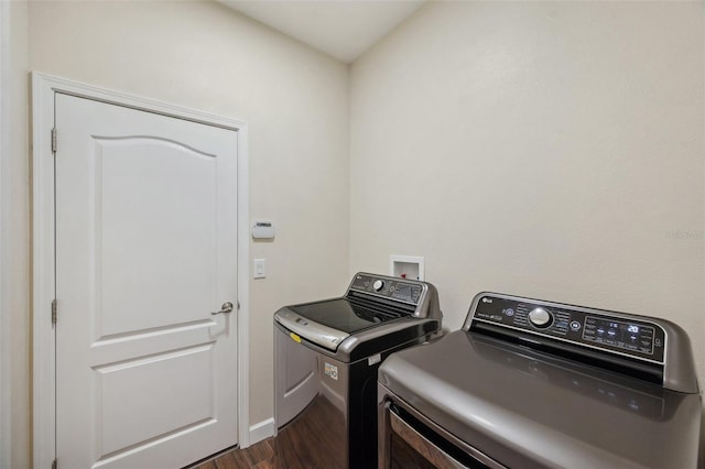 12831 White Bluff Rd, Hudson, FL 34669 - washroom featuring washer and clothes dryer, dark wood-style floors, and baseboards