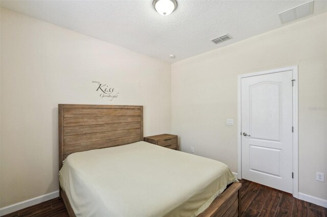 12831 White Bluff Rd, Hudson, FL 34669 - bedroom with baseboards, dark wood-style flooring, and a textured ceiling