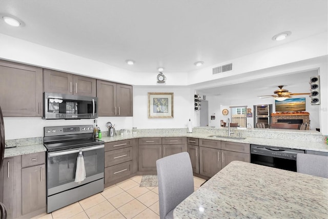 kitchen featuring a sink, stainless steel appliances, visible vents, dark brown cabinetry, and light tile patterned floors