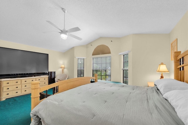 bedroom featuring a ceiling fan, lofted ceiling, and a textured ceiling