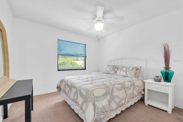 bedroom featuring a textured ceiling, carpet, baseboards, and a ceiling fan