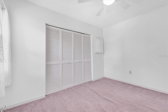 unfurnished bedroom with a ceiling fan, carpet flooring, a closet, and baseboards