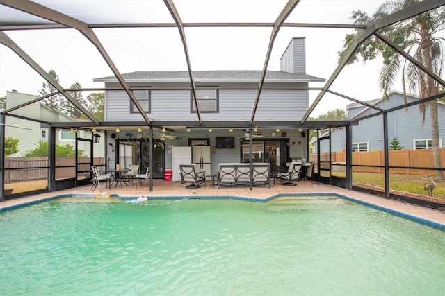 view of swimming pool with ceiling fan, a lanai, a patio, and a fenced in pool