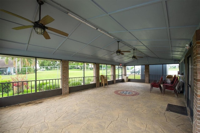 sunroom / solarium featuring stone flooring, a healthy amount of sunlight, and brick wall