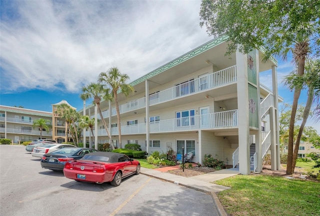view of apartment building / complex featuring uncovered parking