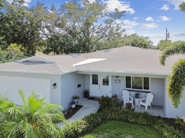 5235 42nd St S, Saint Petersburg, FL 33711 - view of front of home featuring roof with shingles, an attached garage, and stucco siding