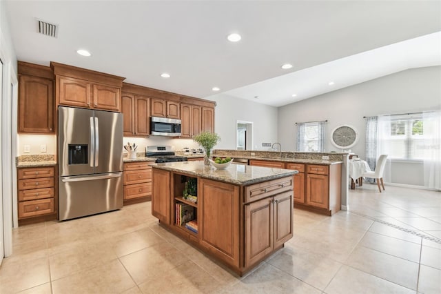 5235 42nd St S, Saint Petersburg, FL 33711 - kitchen with stainless steel appliances, a peninsula, brown cabinetry, a sink, and vaulted ceiling