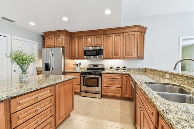 5235 42nd St S, Saint Petersburg, FL 33711 - kitchen with appliances with stainless steel finishes, a sink, recessed lighting, light stone counters, and brown cabinetry