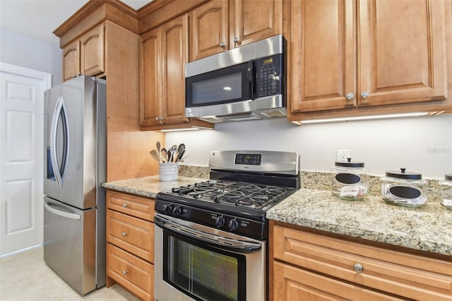 5235 42nd St S, Saint Petersburg, FL 33711 - kitchen featuring appliances with stainless steel finishes, light stone countertops, and brown cabinetry