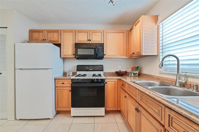 5356 81st St N Unit 26, Saint Petersburg, FL 33709 - kitchen with freestanding refrigerator, black microwave, gas range, a sink, and a textured ceiling