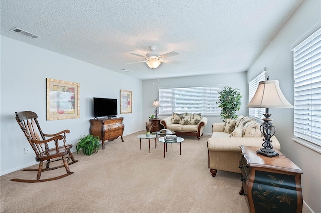 5356 81st St N Unit 26, Saint Petersburg, FL 33709 - living room with healthy amount of natural light, ceiling fan, a textured ceiling, and light carpet