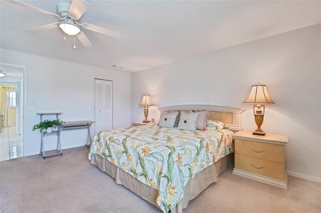 5356 81st St N Unit 26, Saint Petersburg, FL 33709 - bedroom with light colored carpet, a textured ceiling, a closet, a ceiling fan, and baseboards