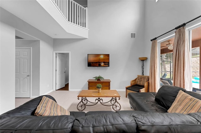 tiled living room featuring baseboards, a high ceiling, and visible vents