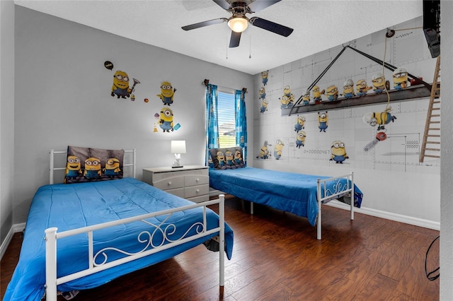 bedroom featuring baseboards, ceiling fan, a textured ceiling, and wood finished floors