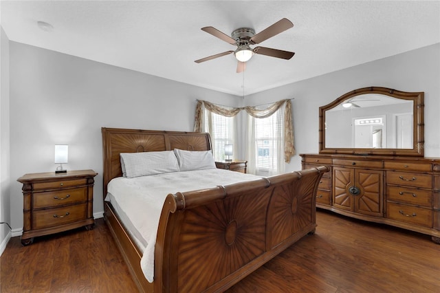bedroom with baseboards, a ceiling fan, and dark wood-style flooring