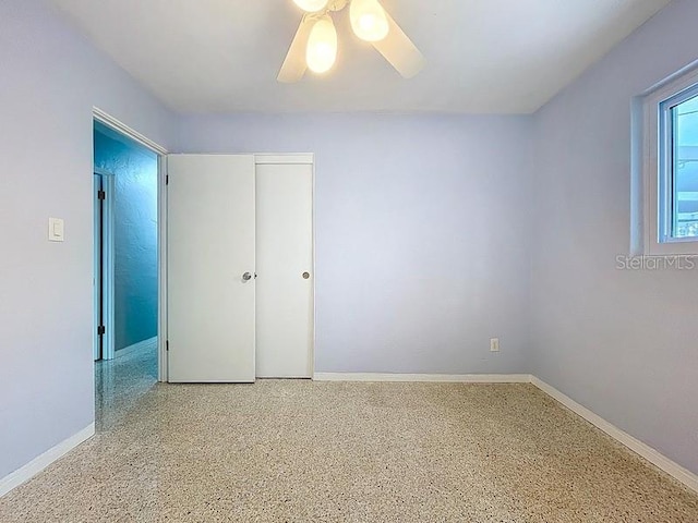 6268 39th Ave N, Saint Petersburg, FL 33709 - unfurnished bedroom with baseboards, ceiling fan, speckled floor, and a closet