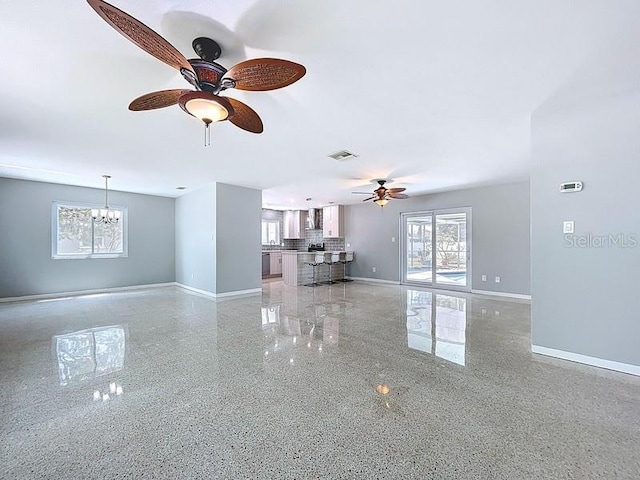 6268 39th Ave N, Saint Petersburg, FL 33709 - unfurnished living room featuring baseboards, ceiling fan with notable chandelier, visible vents, and a wealth of natural light