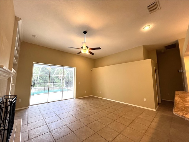 unfurnished living room featuring a ceiling fan, visible vents, and tile patterned flooring