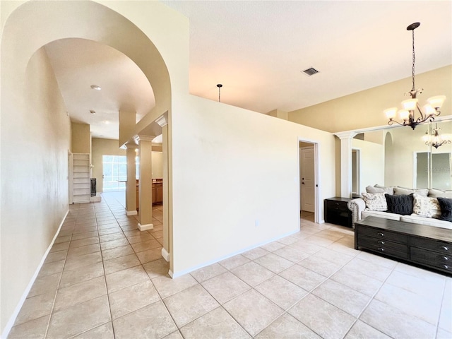 kitchen with ornate columns, arched walkways, light tile patterned flooring, and open floor plan