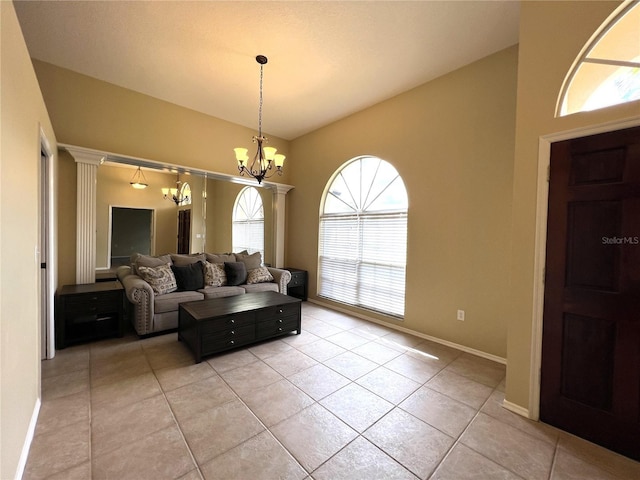 living area featuring baseboards, light tile patterned floors, and a chandelier