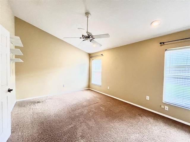 carpeted empty room with a ceiling fan, baseboards, and lofted ceiling