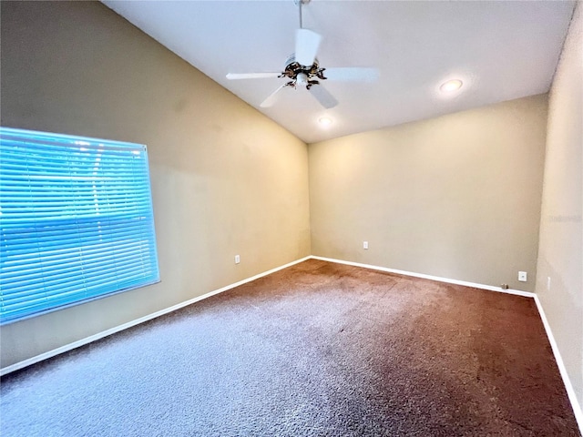 unfurnished room with vaulted ceiling, carpet floors, baseboards, and a ceiling fan