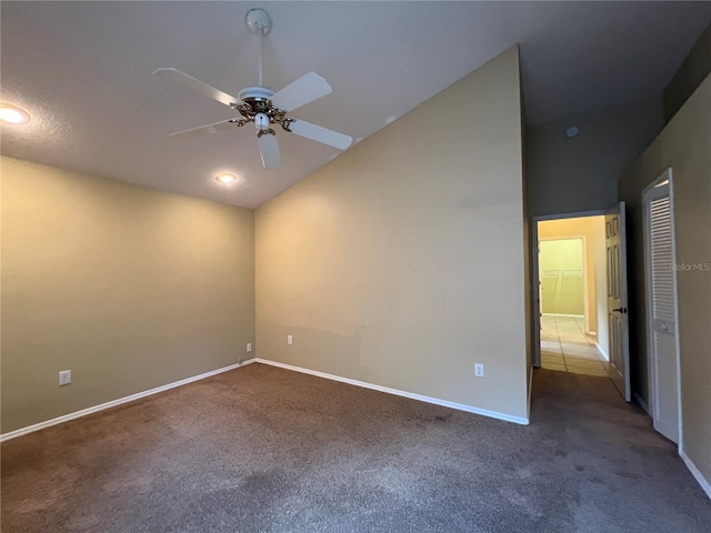 empty room featuring carpet floors, baseboards, ceiling fan, and lofted ceiling