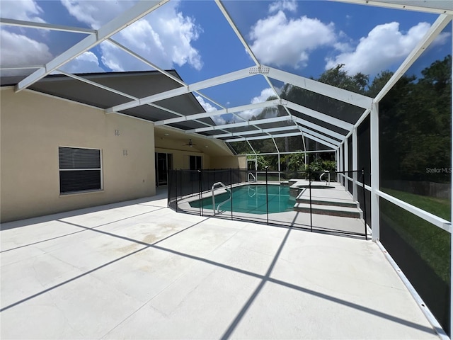 outdoor pool featuring a patio, a ceiling fan, and glass enclosure