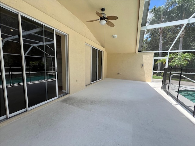 view of patio featuring glass enclosure, a ceiling fan, and an outdoor pool