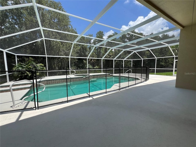 outdoor pool featuring a patio area, a lanai, and an in ground hot tub