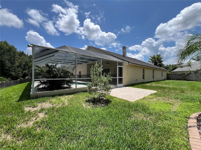 rear view of property featuring ceiling fan, fence, a patio, a fenced in pool, and a lawn