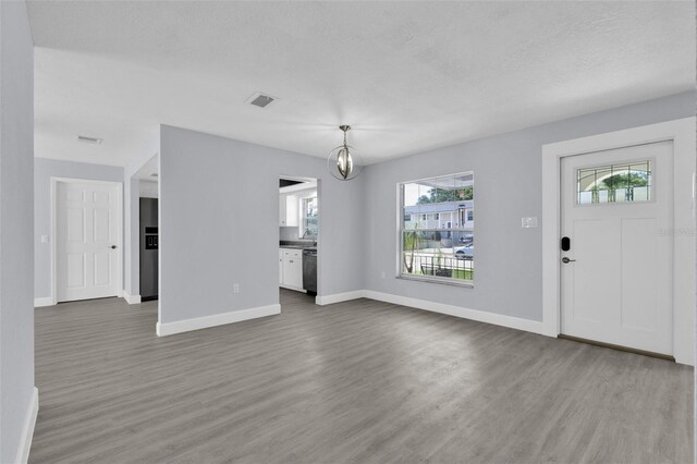 1913 Poinsetta Ln, Maitland, FL 32751 - unfurnished living room featuring wood finished floors, baseboards, healthy amount of natural light, and a chandelier