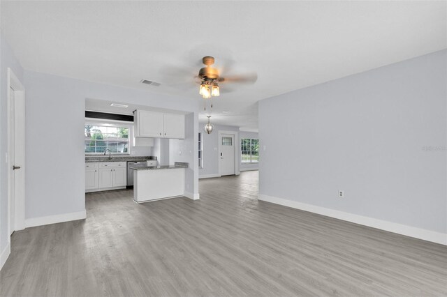 1913 Poinsetta Ln, Maitland, FL 32751 - unfurnished living room with light wood-style floors, ceiling fan, baseboards, and a sink