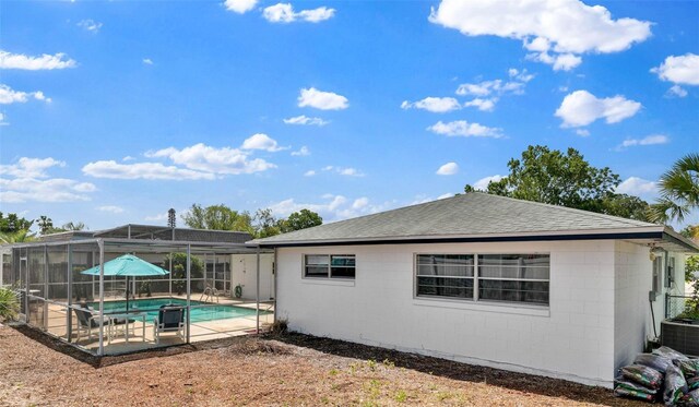 1913 Poinsetta Ln, Maitland, FL 32751 - rear view of house featuring a patio area, a shingled roof, concrete block siding, glass enclosure, and central air condition unit