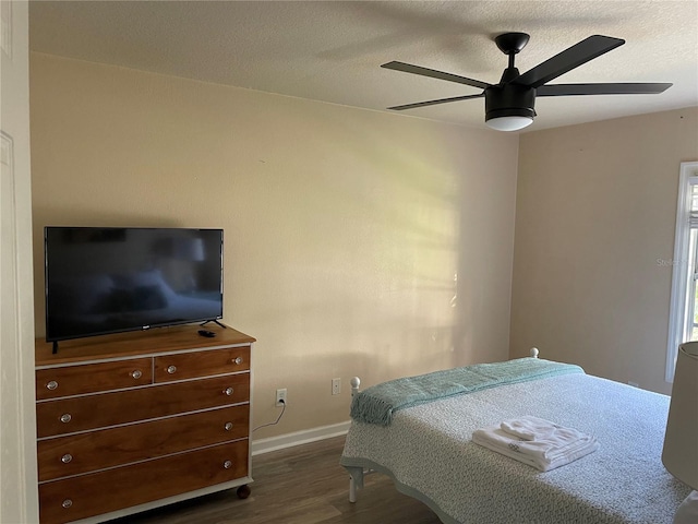 bedroom featuring baseboards, ceiling fan, a textured ceiling, and dark wood-type flooring