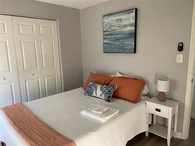 bedroom featuring baseboards, a closet, and wood finished floors
