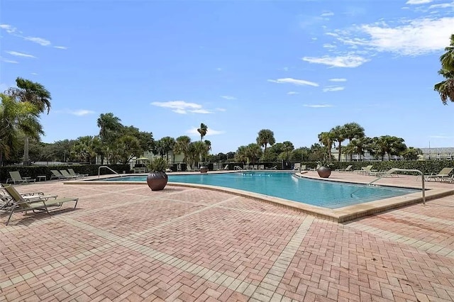 pool with a patio and fence