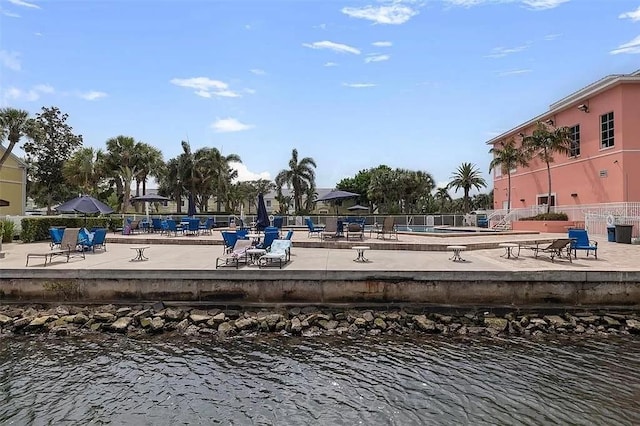 view of home's community with a patio, a water view, and fence