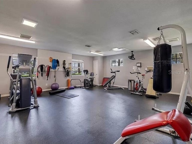 exercise room with baseboards and visible vents