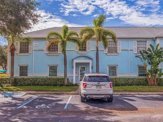 view of front of property with uncovered parking and stucco siding