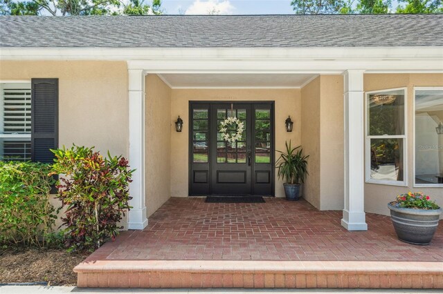 3906 Floyd Rd, Tampa, FL 33618 - property entrance with stucco siding, a shingled roof, and french doors