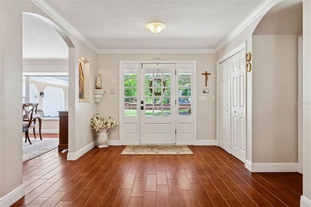 3906 Floyd Rd, Tampa, FL 33618 - entrance foyer with arched walkways, dark wood-style flooring, a textured ceiling, baseboards, and crown molding