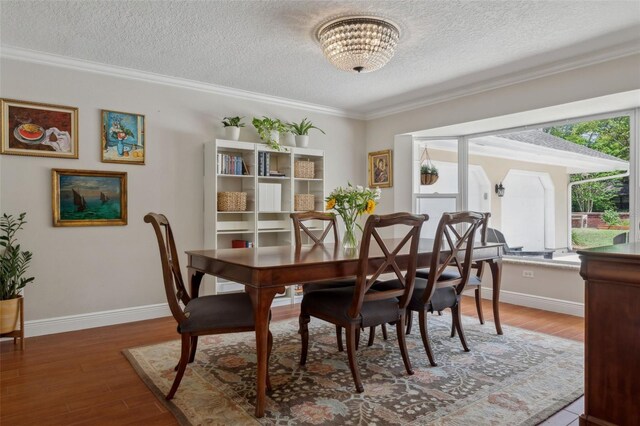 3906 Floyd Rd, Tampa, FL 33618 - dining space featuring a textured ceiling, a chandelier, wood finished floors, crown molding, and baseboards