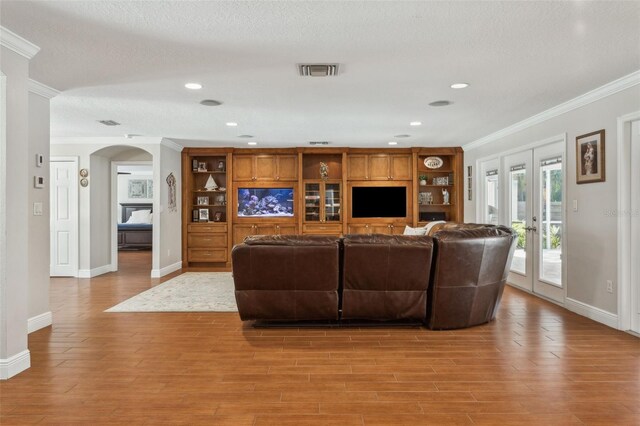 3906 Floyd Rd, Tampa, FL 33618 - living area with crown molding, french doors, baseboards, arched walkways, and light wood finished floors