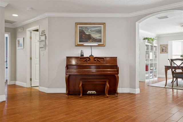 3906 Floyd Rd, Tampa, FL 33618 - living room featuring arched walkways, wood finished floors, crown molding, baseboards, and recessed lighting