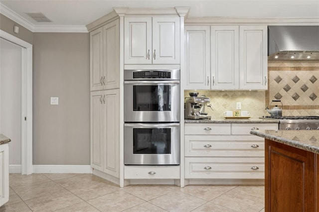 3906 Floyd Rd, Tampa, FL 33618 - kitchen featuring appliances with stainless steel finishes, wall chimney range hood, decorative backsplash, light stone countertops, and light tile patterned floors